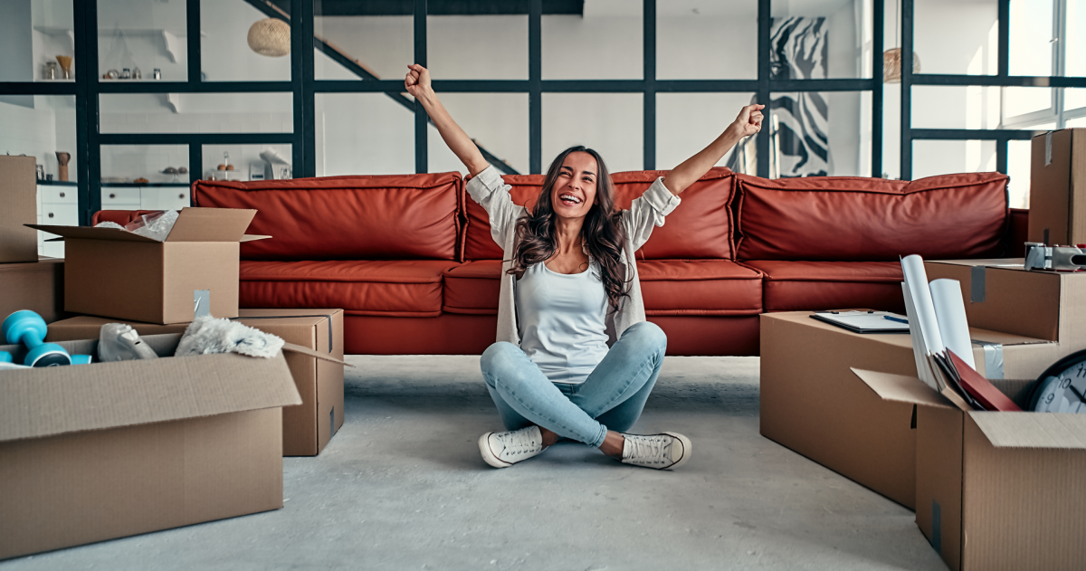 Een vrolijke jonge vrouw die blij is met haar eerste huis